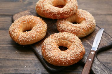 Tahta arka planda susam tohumlu lezzetli simit tahtası, yakın plan.