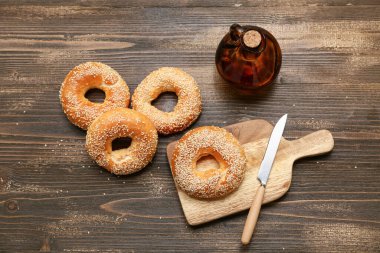 Tahta arka planda susam tohumlu lezzetli simit kesme tahtası