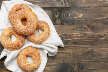 Tahta arka planda susam tohumlu lezzetli simitler.