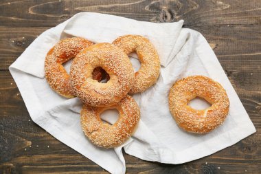 Tahta arka planda susam tohumlu lezzetli simitler.