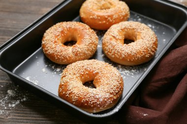 Ahşap zemin üzerinde susam tohumları olan lezzetli simitler pişirmek.