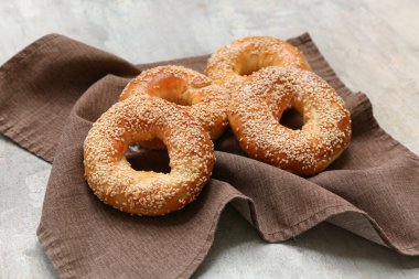 Gri arka planda susam tohumlu lezzetli simitler.