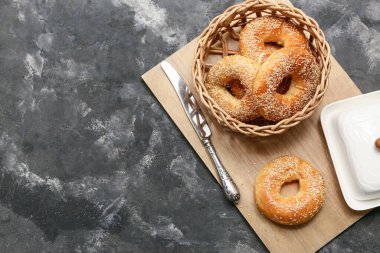 Siyah arka planda susam tohumlu bir kase lezzetli simit.
