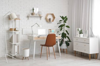 Ofisinde dizüstü bilgisayarı olan modern şık bir iş yeri.