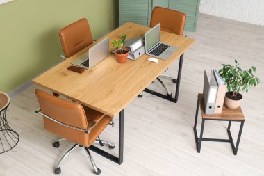 Laptopları toplantı için hazırlanmış modern ofisin içi.