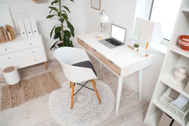 Modern ofiste dizüstü bilgisayarı olan rahat bir iş yeri