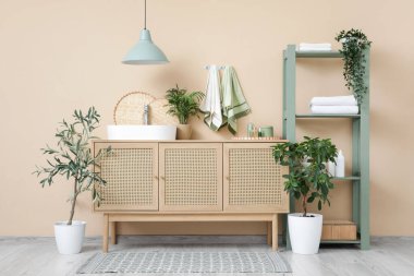 Lavabosu, havlusu ve raf ünitesi olan banyonun içi.