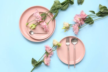 Mavi arka planda güzel östoma çiçekleri olan şık masa ayarları