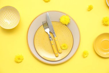 Sarı arka planda güzel karahindiba çiçekleri olan şık bir masa.