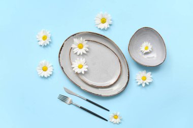 Mavi arka planda güzel kasımpatı çiçekleri olan şık bir masa.