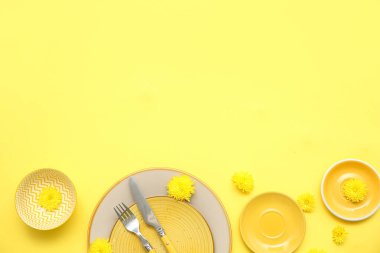 Sarı arka planda güzel karahindiba çiçekleri olan şık bir masa.