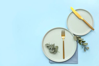 Mavi zemin üzerinde okaliptüs bulunan şık masa ayarları