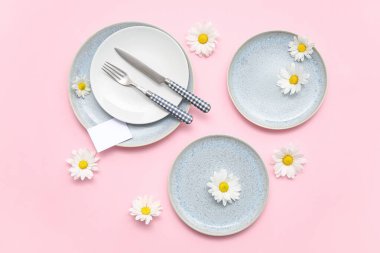 Pembe arka planda güzel kasımpatı çiçekleri olan şık bir masa.