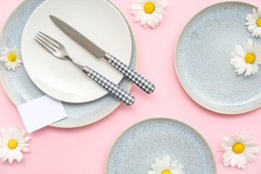 Pembe arka planda güzel kasımpatı çiçekleri olan şık bir masa.