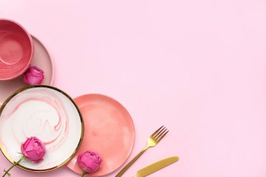 Pembe arka planda güzel gül çiçekleri olan şık bir masa.