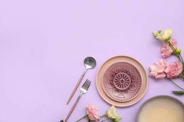 Leylak arka planında güzel östoma çiçekleri olan şık masa ayarları