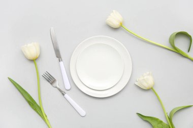 Gri arkaplanda güzel lale çiçekleri olan şık masa ayarları