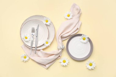 Sarı arka planda güzel beyaz kasımpatı çiçekleri olan şık masa ayarı