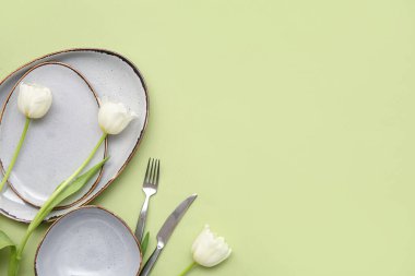 Yeşil arka planda güzel lale çiçekleri olan şık masa ayarları