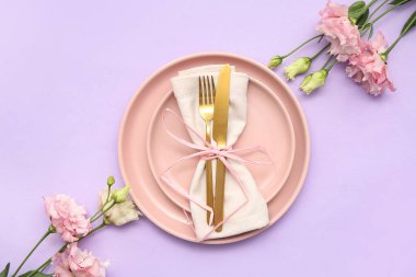 Leylak arka planında güzel östoma çiçekleri olan şık masa ayarları