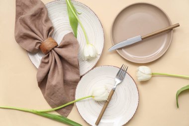 Bej arkaplanda güzel lale çiçekleri olan şık masa ayarları