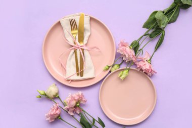 Leylak arka planında güzel östoma çiçekleri olan şık masa ayarları