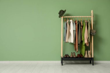 Yeşil duvarın yanında ayakta duran ayakkabılarla dizilin.