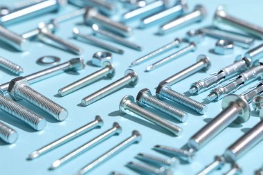 Mavi arka planda farklı musluk cıvataları ve krom fındıklar, yakın plan