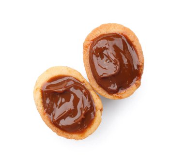 Beyaz arka planda kaynamış yoğunlaştırılmış sütle ceviz şekilli kurabiyeler.