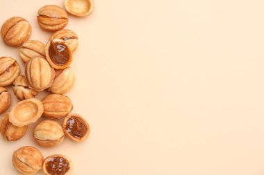 Tatlı ceviz şekilli kurabiyeler ve bej arka planda haşlanmış konsantre süt.