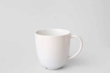 Gri arkaplanda beyaz seramik bardak