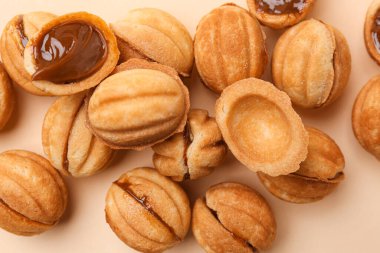 Tatlı ceviz şekilli kurabiyeler ve bej arka planda haşlanmış konsantre süt.