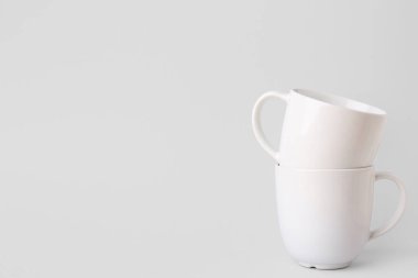 Gri arkaplanda beyaz seramik bardaklar