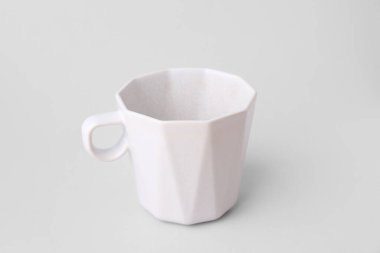 Gri arkaplanda beyaz seramik bardak