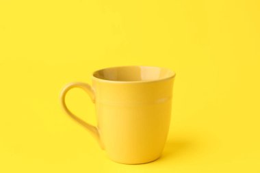 Renkli arkaplanda sarı seramik bardak