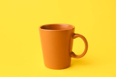 Sarı zemin üzerinde kahverengi seramik bardak