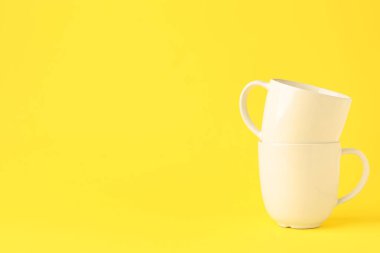 Sarı arkaplanda beyaz seramik bardaklar