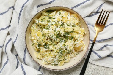 Hafif grunge arka planda çatallı bir tabak lezzetli patates salatası.