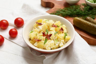 Pastırmalı patates salatası, yeşil soğan, domates ve ahşap kaplama salatalık turşusu.