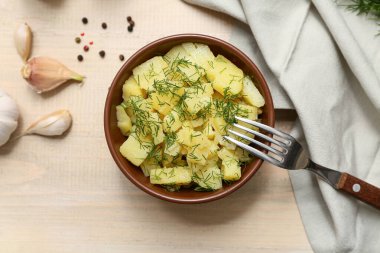 Bej ahşap arka planda dereotlu ve sarımsaklı patates salatası.