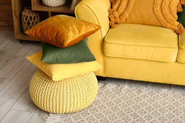 Oturma odasındaki puf üzerinde şık yastıklar.