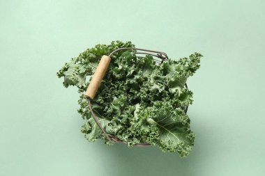 Yeşil arka planda taze lahana yapraklı sepet.