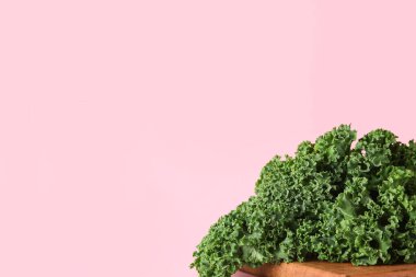 Pembe arka planda taze lahana yaprakları olan ahşap tahta tahta.