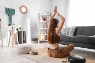 Genç kadın evde meditasyon, geri görünümü