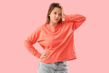 Pembe arka planda merak eden genç bir kadın