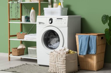 Modern çamaşır odasında sepetli çamaşır makinesi.
