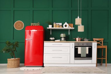 Beyaz tezgah, çatal bıçak ve modern buzdolabı olan şık bir mutfak.