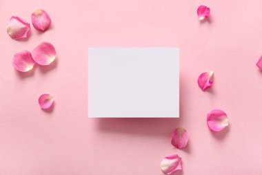 Pembe arka planda gül yaprakları olan boş bir kart.