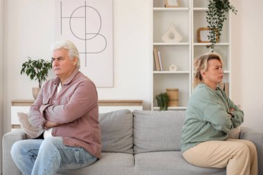 Evdeki kanepede oturan üzgün, olgun bir çift. Boşanma kavramı