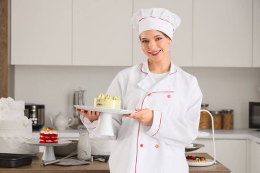 Mutfakta lezzetli pastası olan bir kadın pastacı.